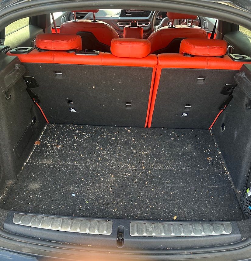 Boot carpet scattered with debris before a deep clean