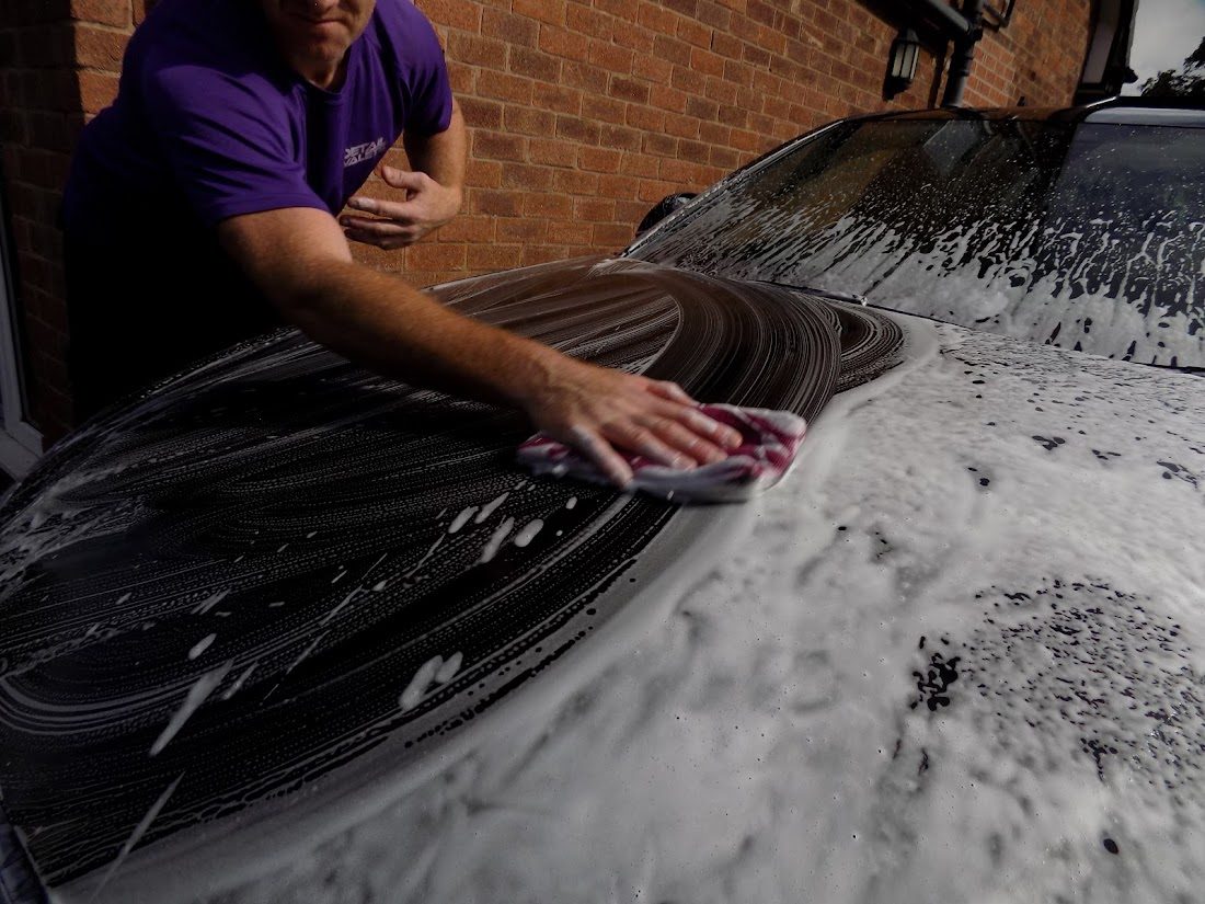 Dan from Detail Valets hand washing a car bonnet using the two bucket method
