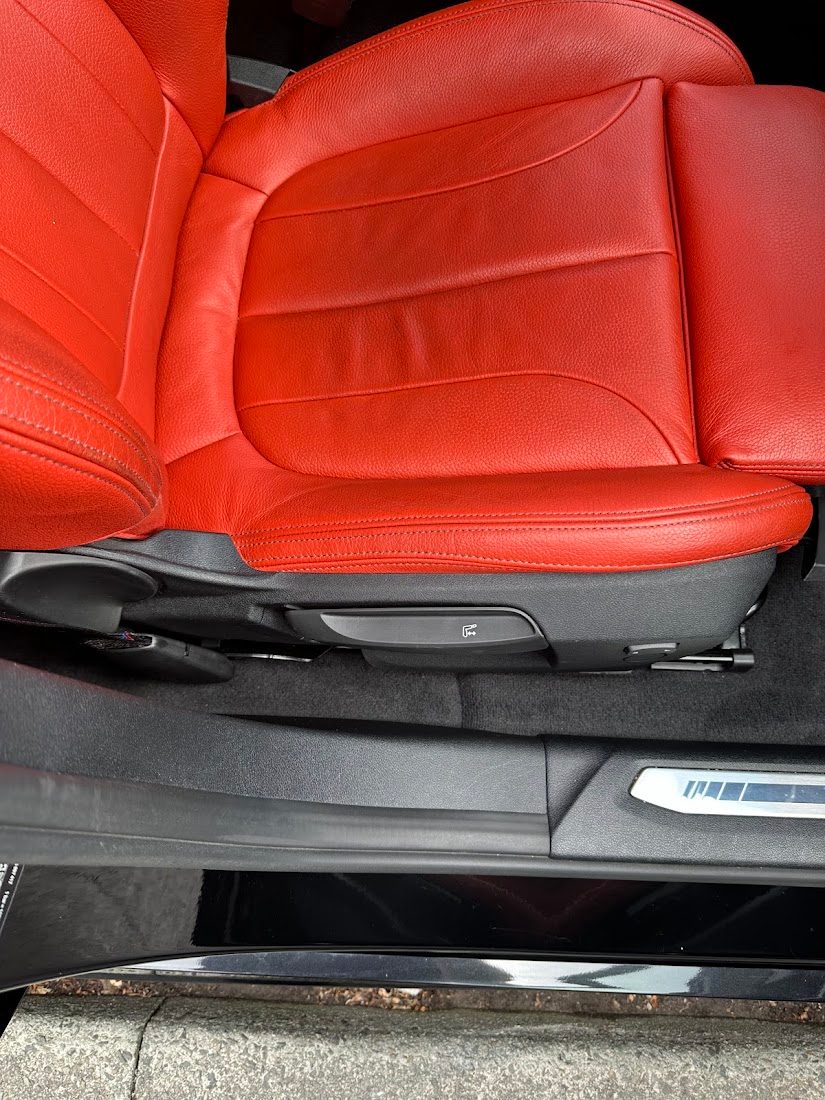 Red leather seat, carpet and sill spotless after a mobile car interior deep clean in Manchester