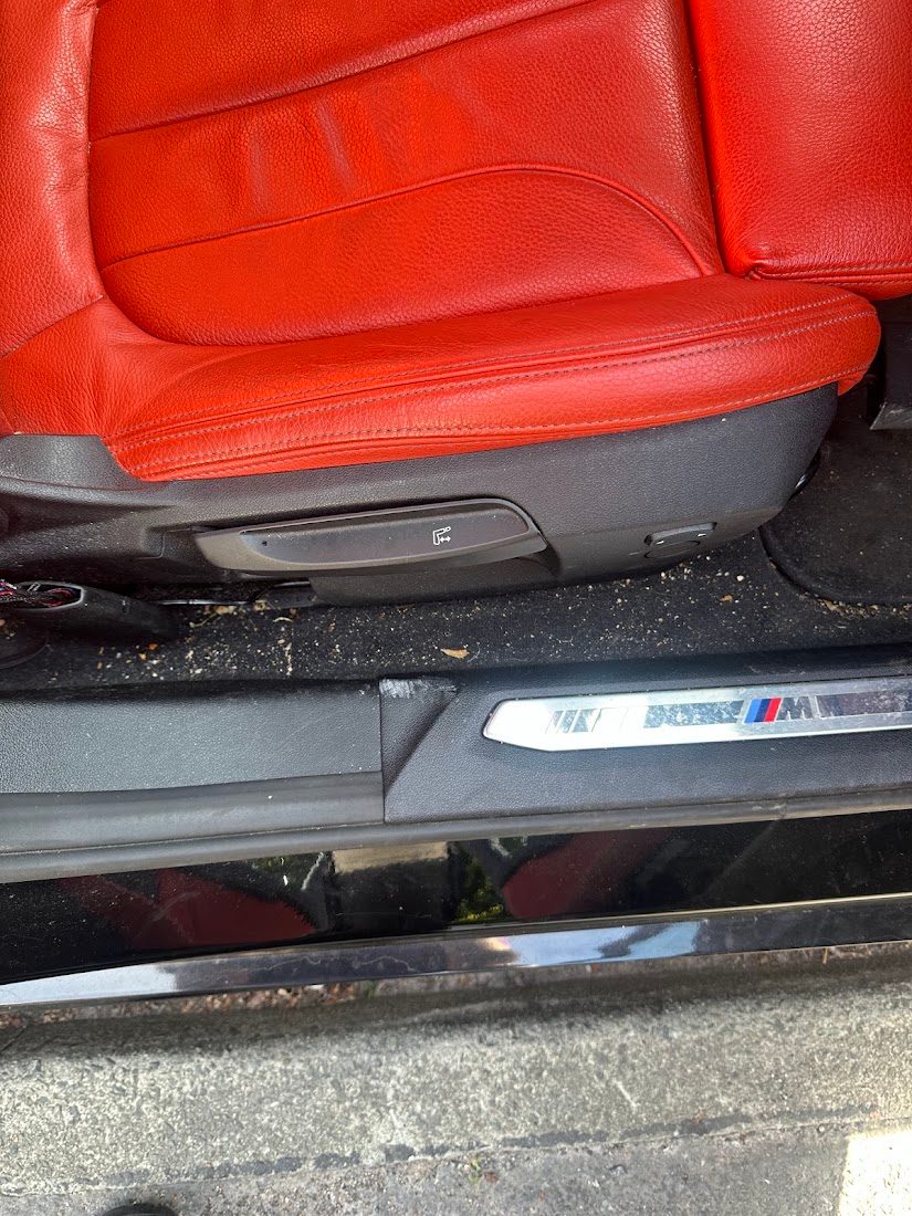Car seat base and door sill covered in crumbs and grit before a deep clean