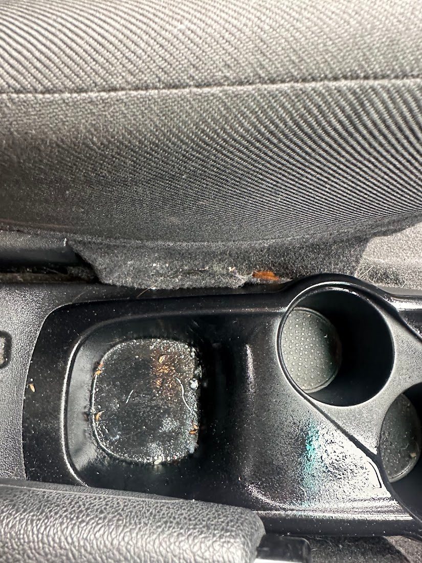 Sticky, dirty cup holders and centre console before an interior deep clean